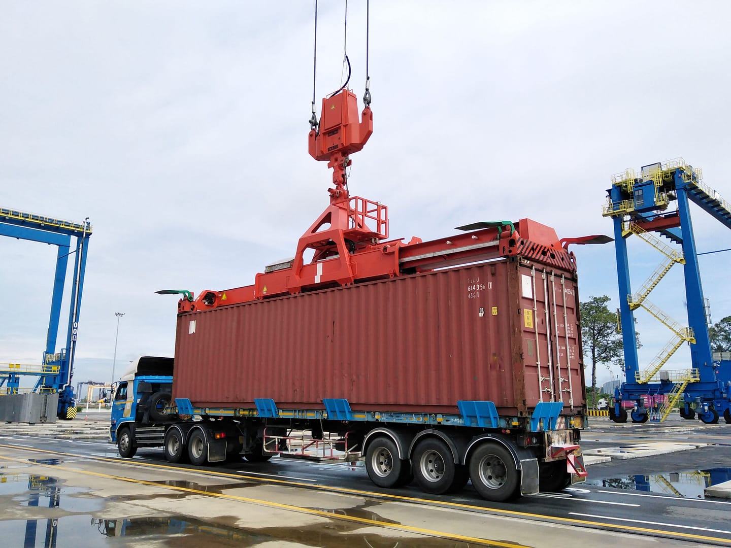 Outside of a bustling Port, FCL Carrier awaits container loading to continue the cargos Journey. FCL, Import Clearance, Delivery, Freight management.
